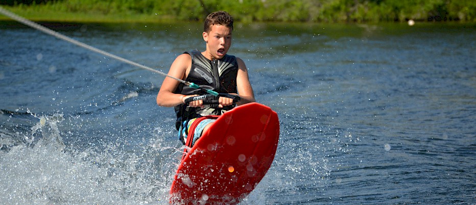 Each encampment spends one afternoon each week at Sunset Beach where they are provided with opportunities to waterski, kneeboard and wakeboard.  This camper appears to be taking flight!