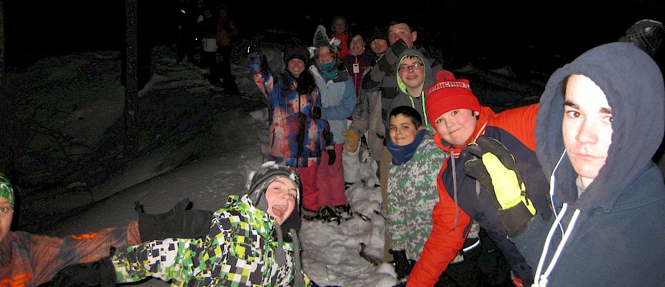 NH Week campers enjoy a traditional "last night of camp" mystery snowshoe adventure.